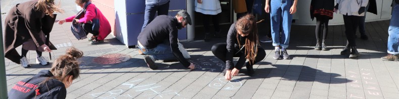 Hópur fólks krítar á gangstétt í Inclusive Public Spaces