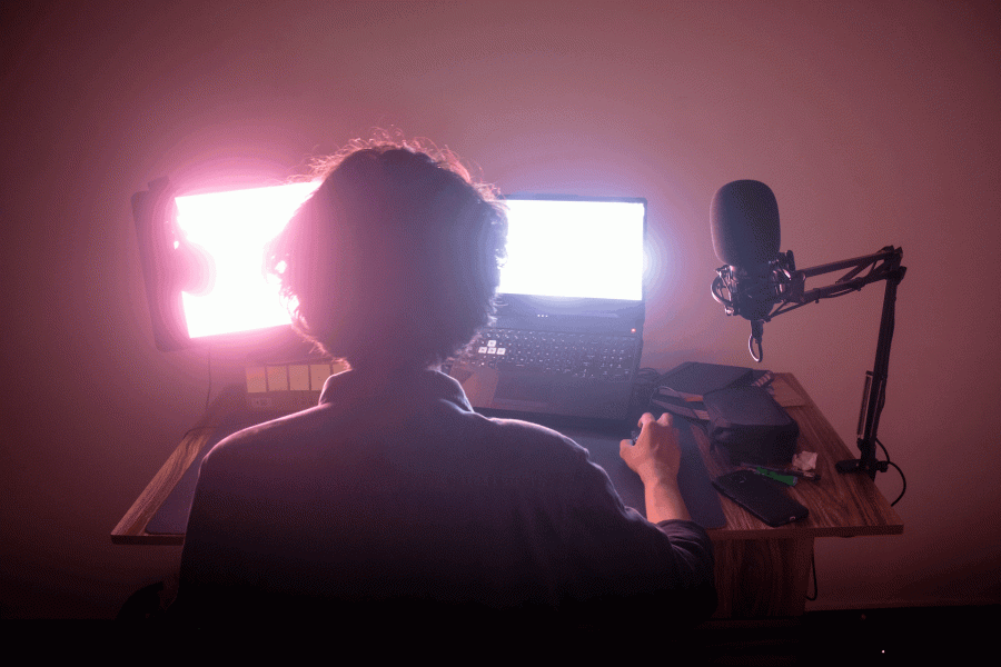 Person working on a bright laptop with podcasting mic
