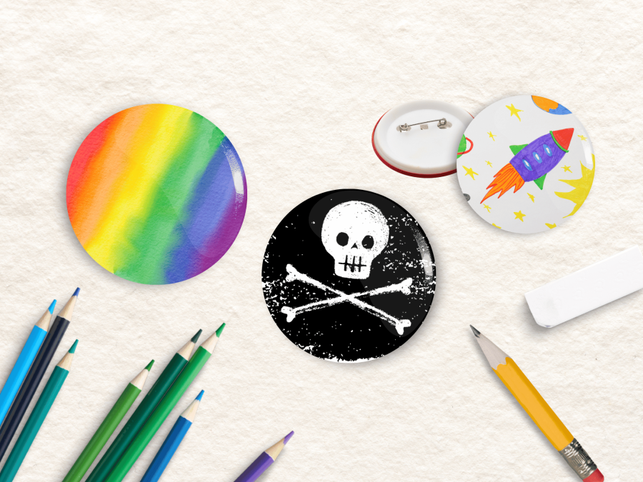 Several button badges, some colour pencils, a small pencil, an eraser.