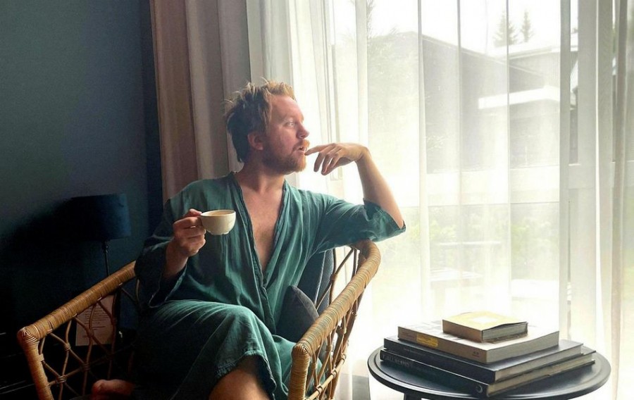 Björn Grétar Baldursson Björn Grétar situr á sófa, íklæddur slopp að drekka kaffi úr bolla