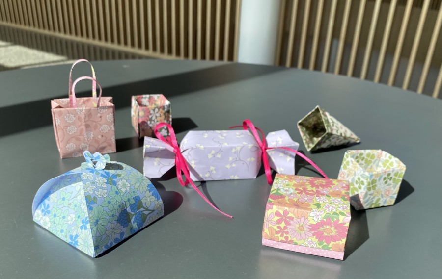 Origami-pappírsgjafaöskur í ýmsum litum og mynstrum á borði